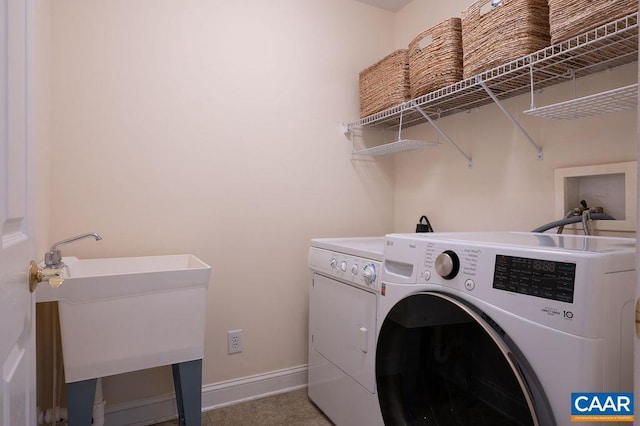 laundry area with independent washer and dryer and baseboards