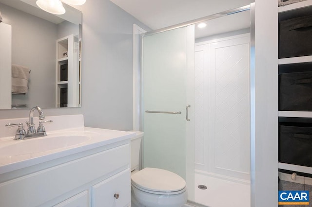 full bath with a stall shower, toilet, vanity, and recessed lighting