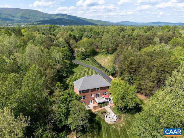 view of subject property featuring a heavily wooded area and a mountainous background