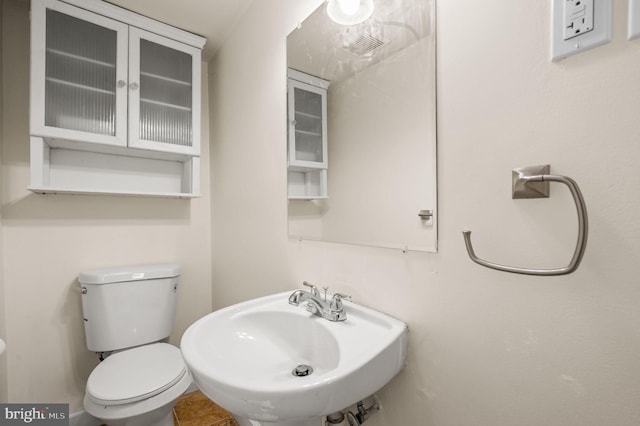 half bath with toilet and a sink