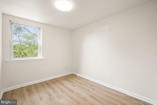 empty room featuring light wood-type flooring and baseboards