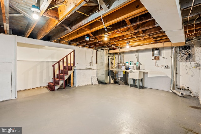 unfinished basement featuring gas water heater and stairs