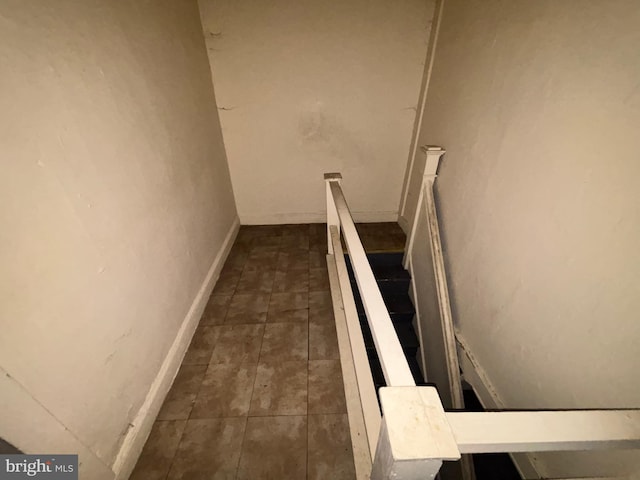 stairs with baseboards and tile patterned floors