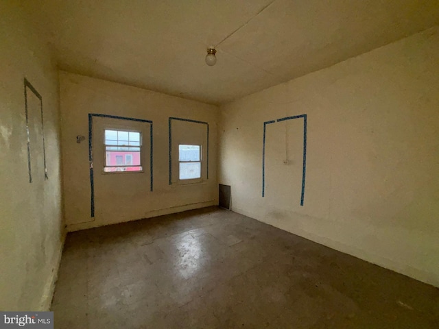 unfurnished room with concrete flooring