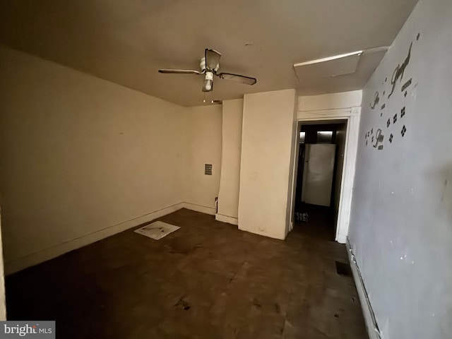 interior space featuring attic access, a ceiling fan, and concrete floors