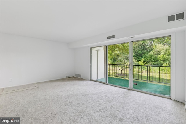 carpeted empty room featuring visible vents