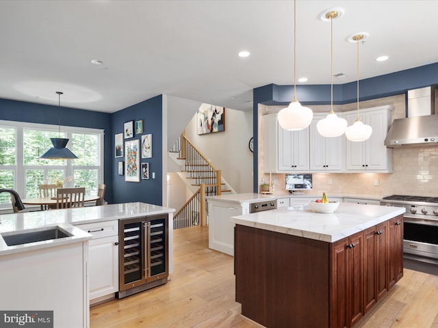 14484 Bluff Point Ct, Gainesville, VA 20155 - kitchen with wall chimney range hood, beverage cooler, a sink, high end stainless steel range oven, and a kitchen island