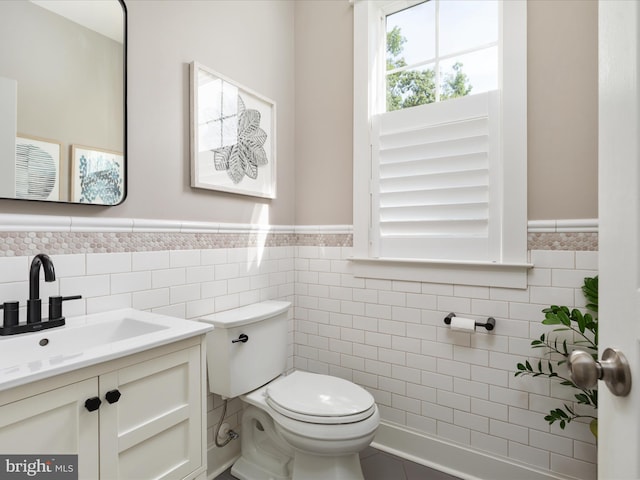 14484 Bluff Point Ct, Gainesville, VA 20155 - half bathroom featuring a wainscoted wall, tile walls, toilet, and vanity