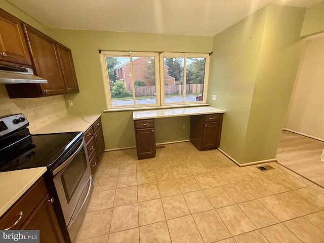 1010 Commanders Way N, Annapolis, MD 21409 - kitchen with electric range, under cabinet range hood, light tile patterned flooring, tasteful backsplash, and baseboards