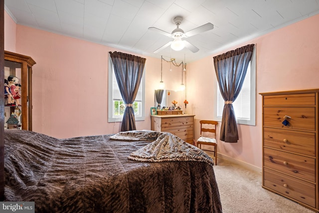 carpeted bedroom with ornamental molding, baseboards, and a ceiling fan