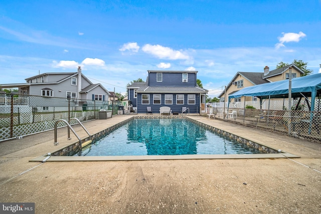 view of pool with a residential view, a fenced in pool, and fence
