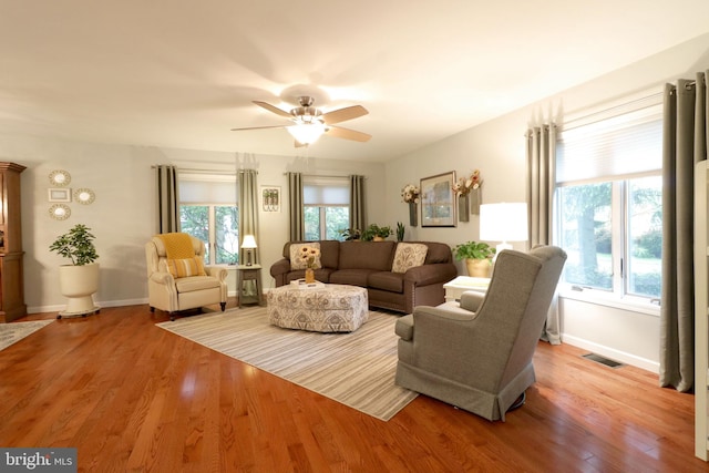 living room with light wood-style flooring, a wealth of natural light, baseboards, and visible vents