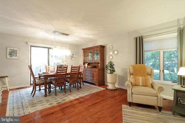 dining room with an inviting chandelier, wood finished floors, and baseboards