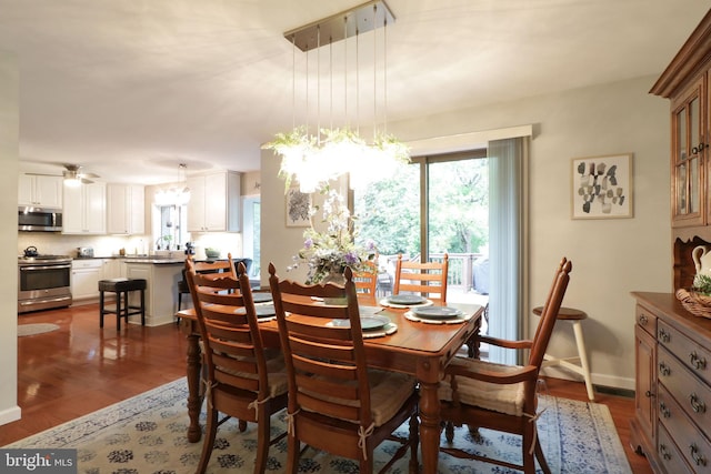 dining space with an inviting chandelier, dark wood-type flooring, and baseboards