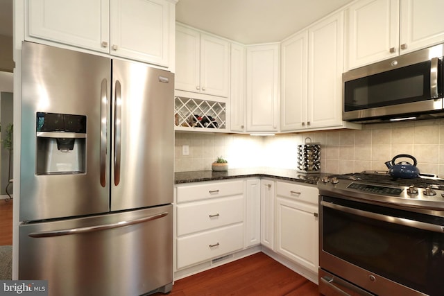 kitchen with backsplash, stainless steel appliances, and white cabinets