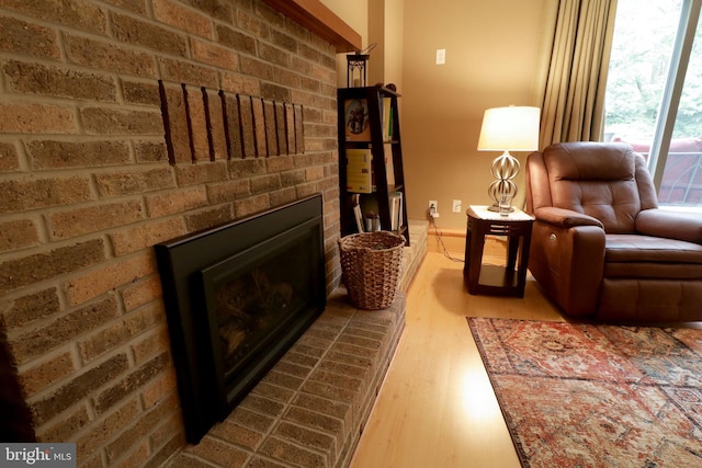 sitting room featuring baseboards, wood finished floors, and a fireplace