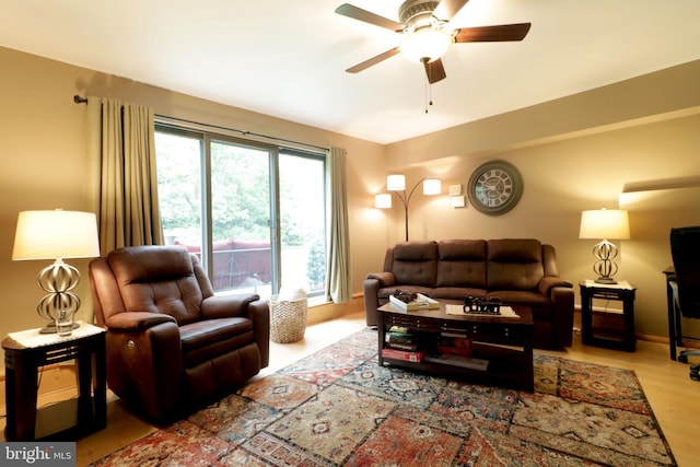 living area with a ceiling fan and wood finished floors