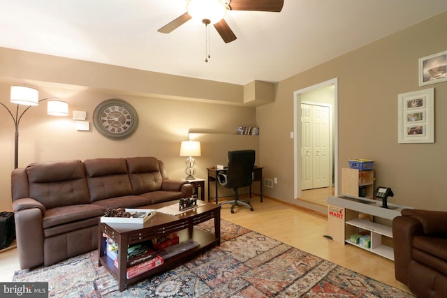 living area with ceiling fan and light wood-style flooring