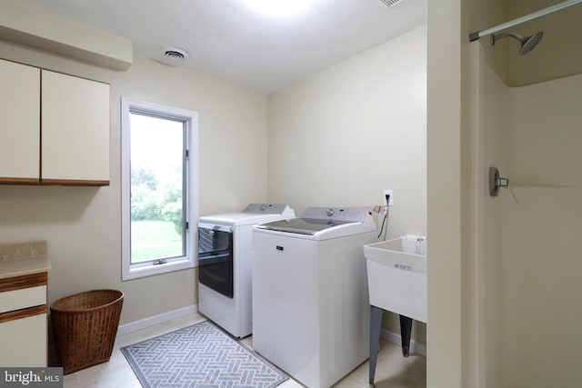 laundry room featuring baseboards, washer and dryer, visible vents, and cabinet space