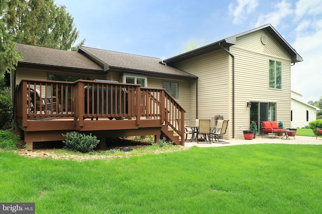 back of house with a lawn, a patio area, a wooden deck, and a shingled roof