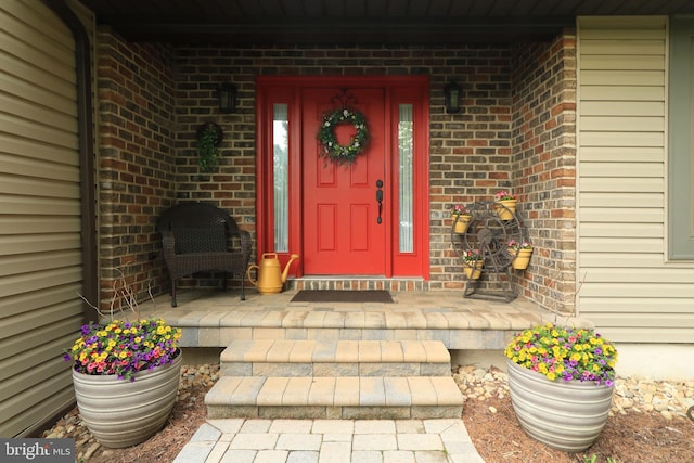 property entrance featuring brick siding and covered porch