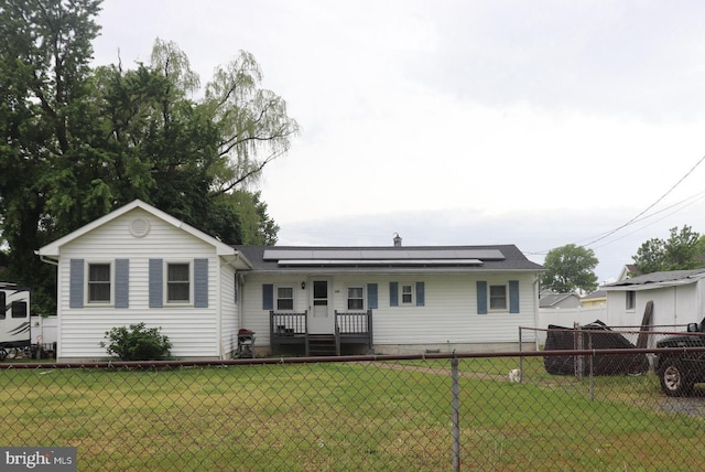 view of front of property featuring solar panels, a front yard, and fence private yard
