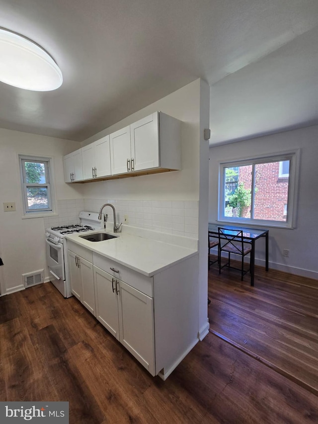 105 S Iris St, Alexandria, VA 22304 - kitchen featuring white range with gas stovetop, dark wood finished floors, and decorative backsplash