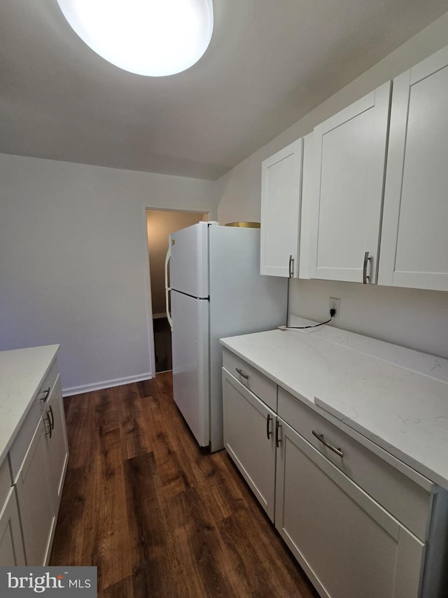 105 S Iris St, Alexandria, VA 22304 - kitchen with dark wood-style floors, light stone counters, white cabinets, and freestanding refrigerator