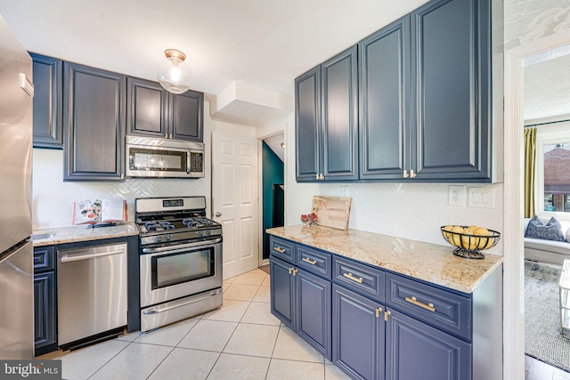 236 Nicholson St NE, Washington, DC 20011 - kitchen with stainless steel appliances, light tile patterned flooring, light stone counters, decorative backsplash, and blue cabinetry