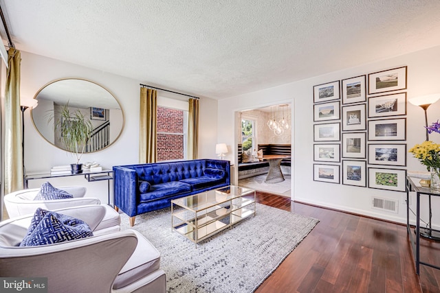 236 Nicholson St NE, Washington, DC 20011 - living area featuring wood finished floors, a textured ceiling, visible vents, baseboards, and a chandelier