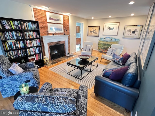 living area featuring wood finished floors, a brick fireplace, and recessed lighting