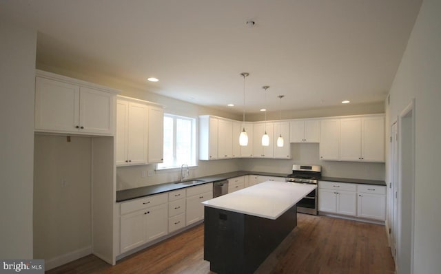 kitchen with stainless steel appliances, a sink, white cabinetry, a kitchen island, and recessed lighting