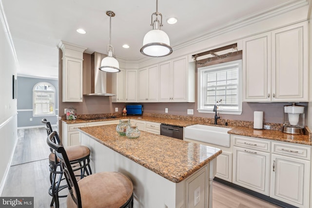 806 209th St, Pasadena, MD 21122 - kitchen featuring a sink, wall chimney range hood, a kitchen breakfast bar, a center island, and light wood-style floors