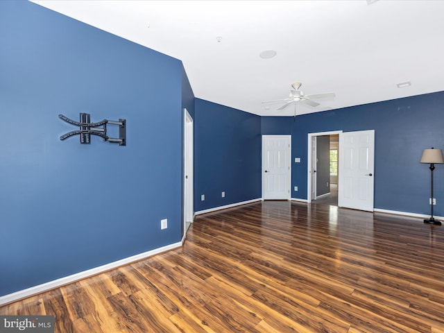 unfurnished room with ceiling fan, wood finished floors, and baseboards