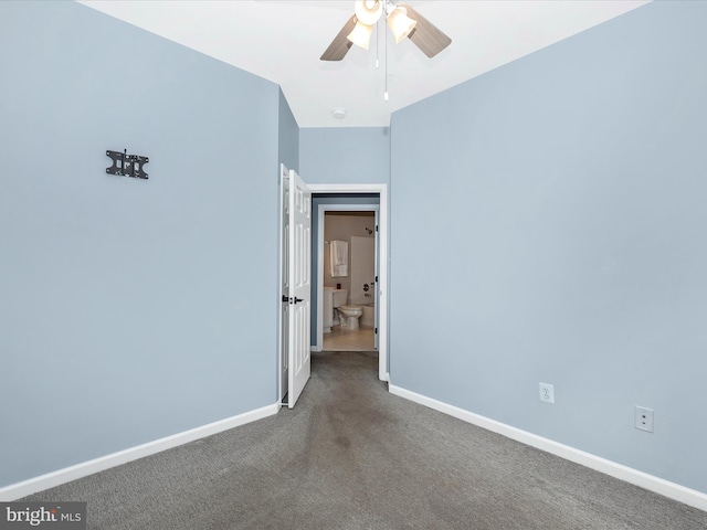 carpeted spare room with a ceiling fan and baseboards
