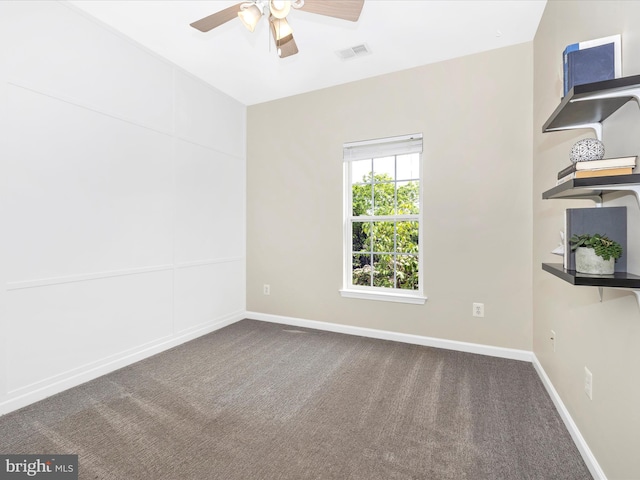 carpeted spare room with ceiling fan and baseboards