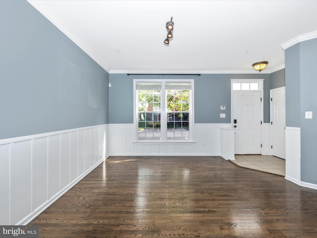 unfurnished living room with ornamental molding, wainscoting, and wood finished floors