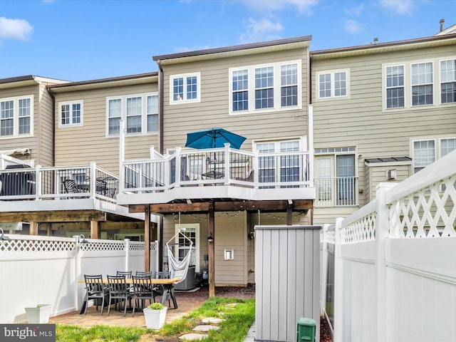 back of property with fence, a deck, and central air condition unit