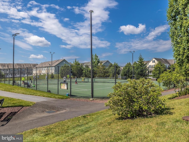 view of tennis court with a residential view