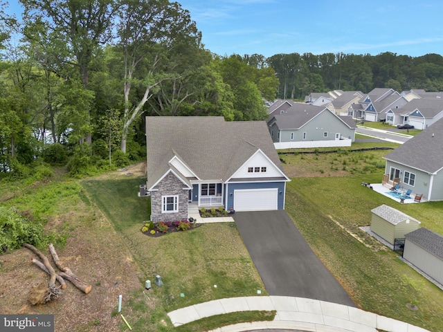 40 Doc Ct, Felton, DE 19943 - view of front of home featuring stone siding, an attached garage, asphalt driveway, and a front lawn