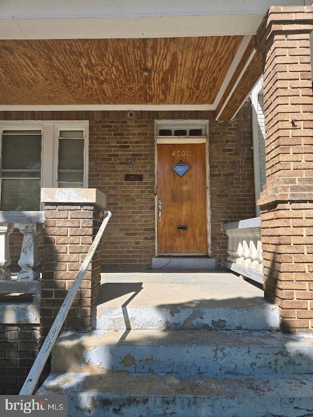 doorway to property featuring brick siding