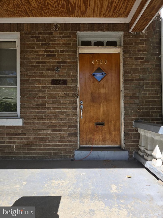view of exterior entry featuring brick siding