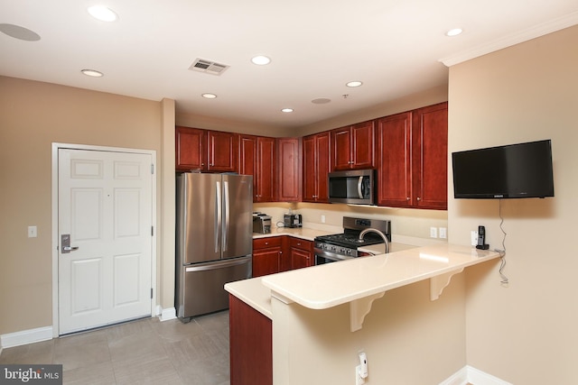 kitchen with stainless steel appliances, a peninsula, baseboards, light countertops, and a breakfast bar area