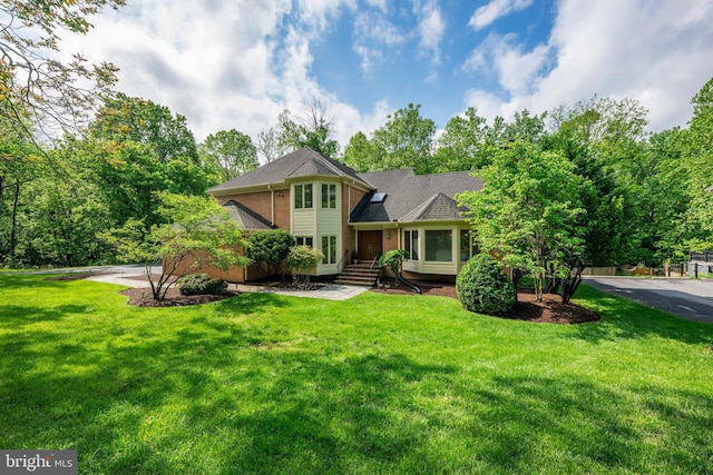view of front of house featuring brick siding and a front yard