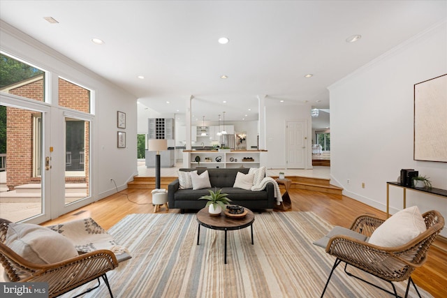 living area featuring light wood finished floors, recessed lighting, baseboards, and ornamental molding