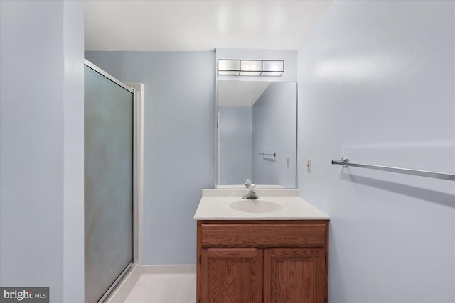 full bath with a stall shower, vanity, and baseboards