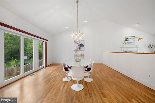 unfurnished dining area with vaulted ceiling, wood finished floors, baseboards, and a chandelier