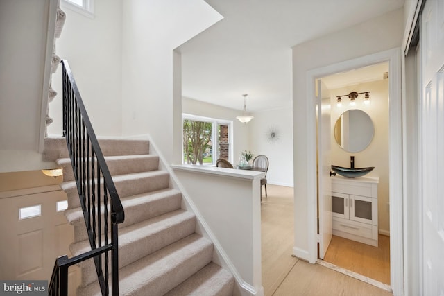 stairs with wood finished floors and baseboards