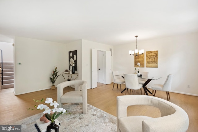living room featuring a chandelier, stairs, wood finished floors, and baseboards