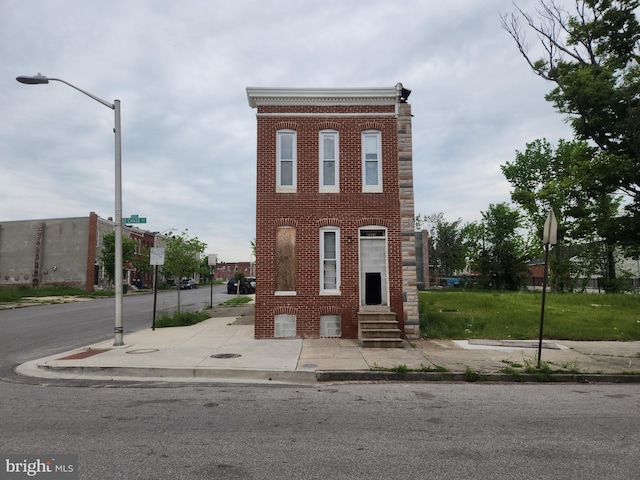 view of front of home with entry steps and brick siding